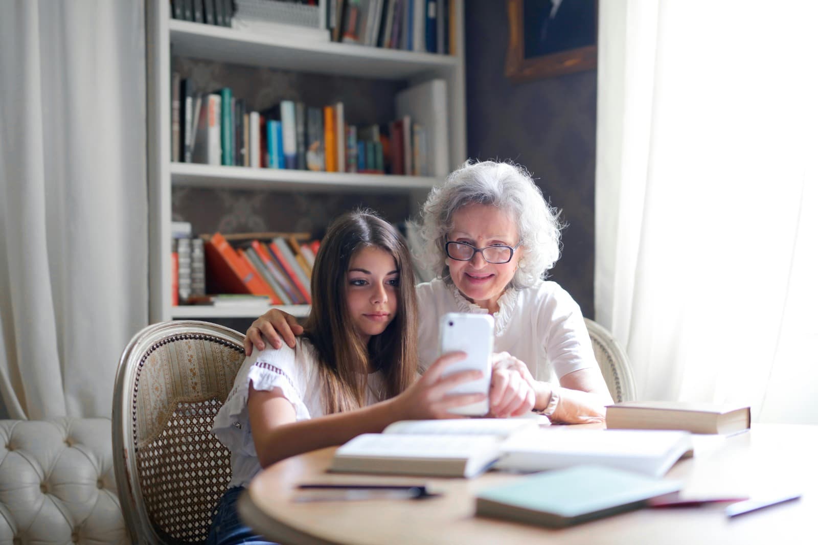 Grandmother showing granddaughter how to use phone